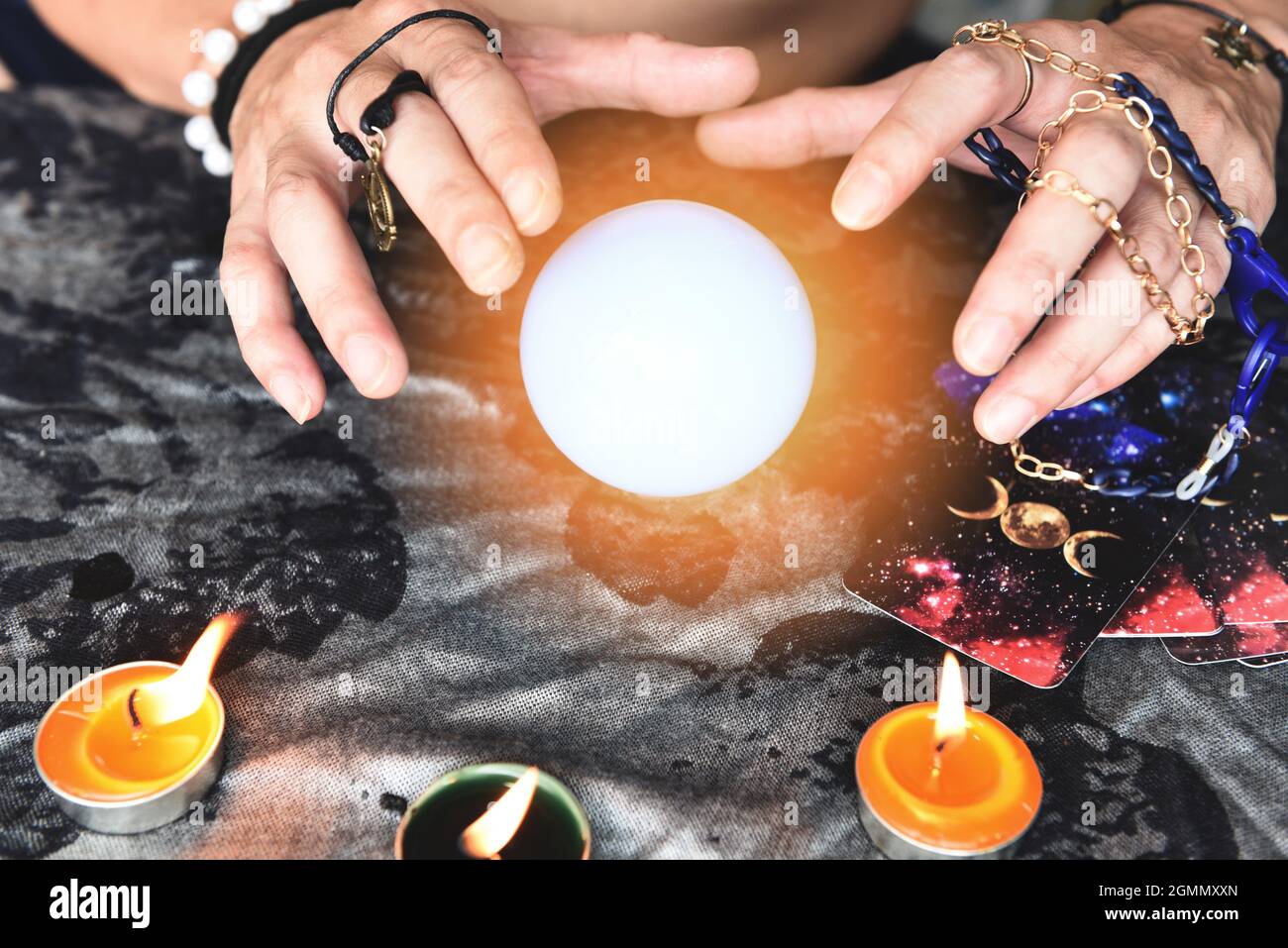 Show fortune tellers of hands holding tarot cards and tarot reader with candle light and magic Crystal ball, Performing readings magical performances, Stock Photo