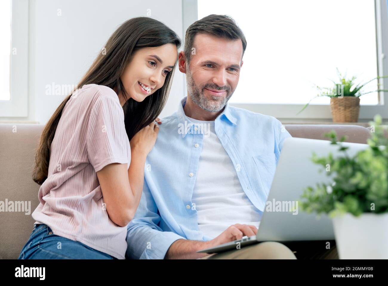 Couple using laptop, watching movie, browsing internet. Happy couple. Stock Photo