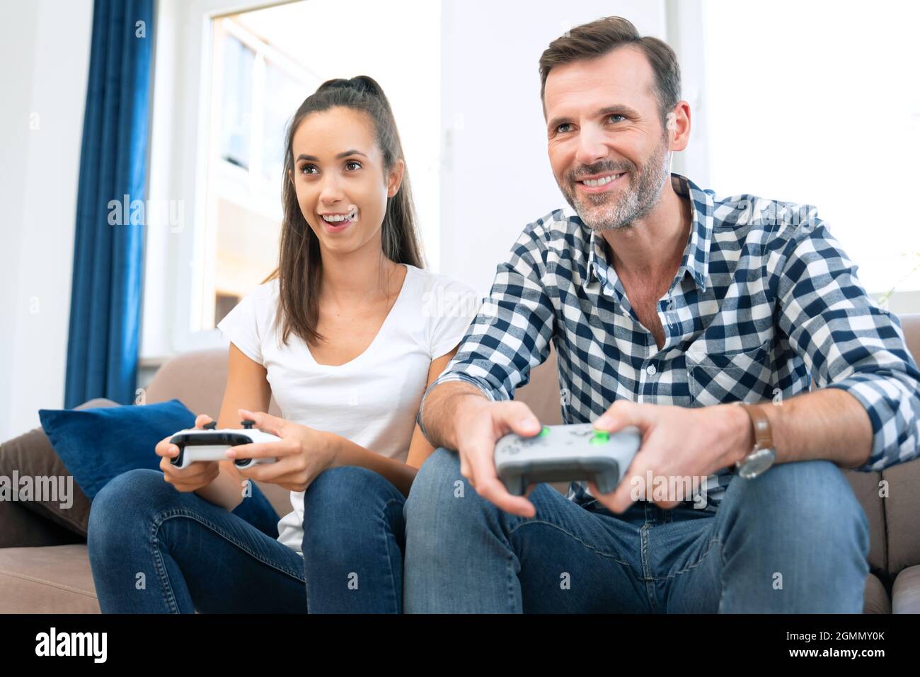Couple playing computer games, playing the console, holding pads in