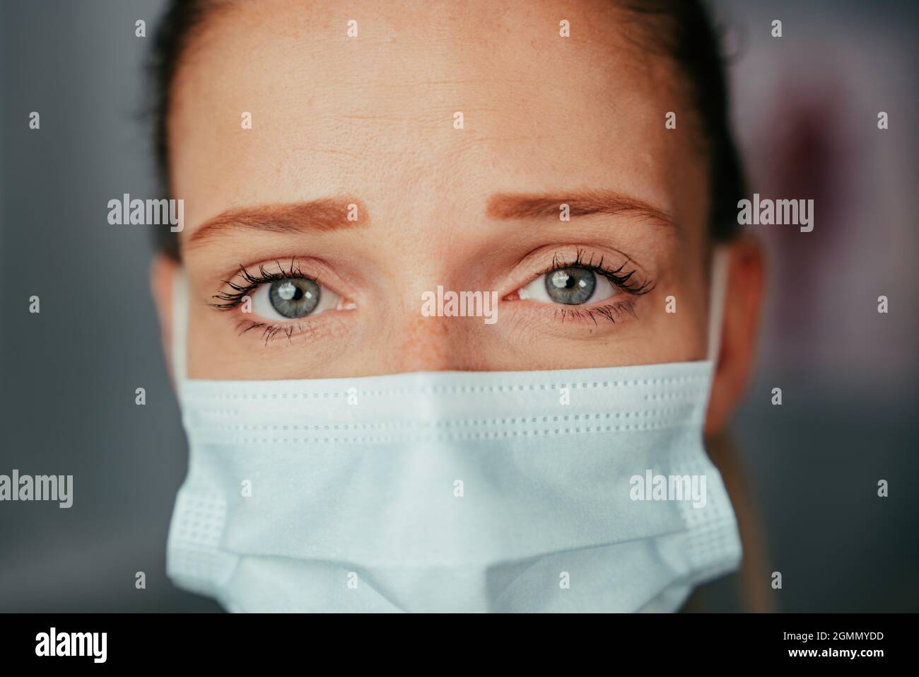 Caucasian female nurse trainee standing in doctors office wearing mask Stock Photo