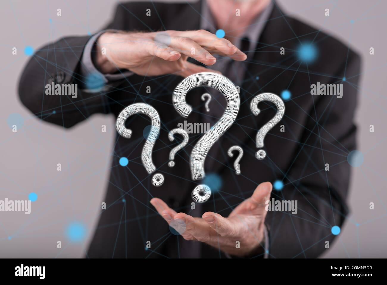 Question concept between hands of a man in background Stock Photo