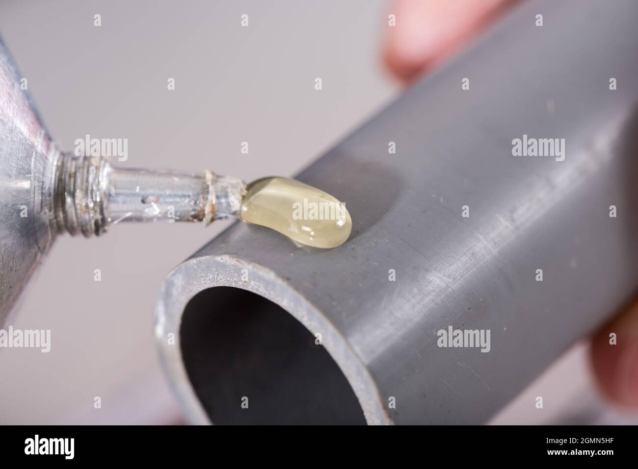 Plumber putting glue on a pvc pipe, closeup Stock Photo Alamy