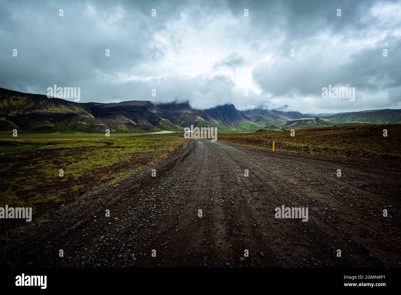 Driving on an unpaved road in summer in Iceland, moutains landscape, moody sky with dark clouds Stock Photo