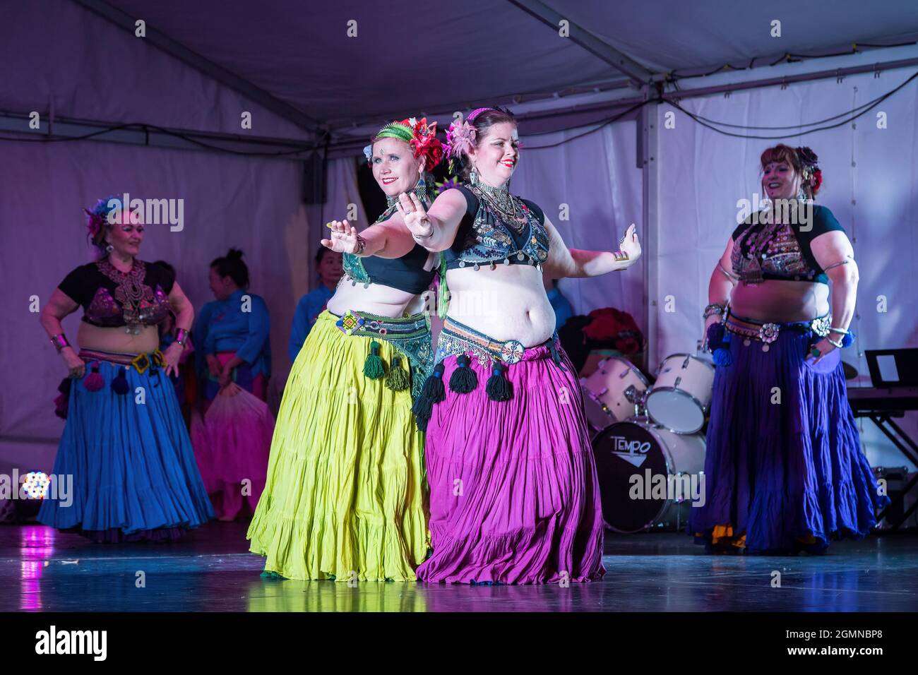 Tribal belly dancers in colorful gypsy costumes performing on stage Stock Photo