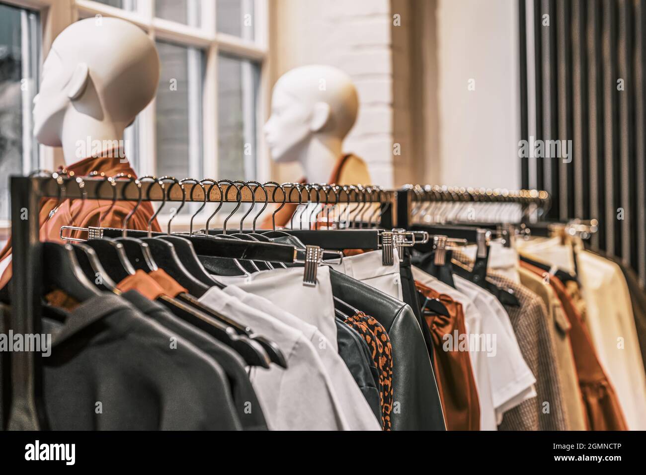 Clothes on hangers, sale in shop, assortment in clothing store, mannequin  heads. Selective focus Stock Photo - Alamy