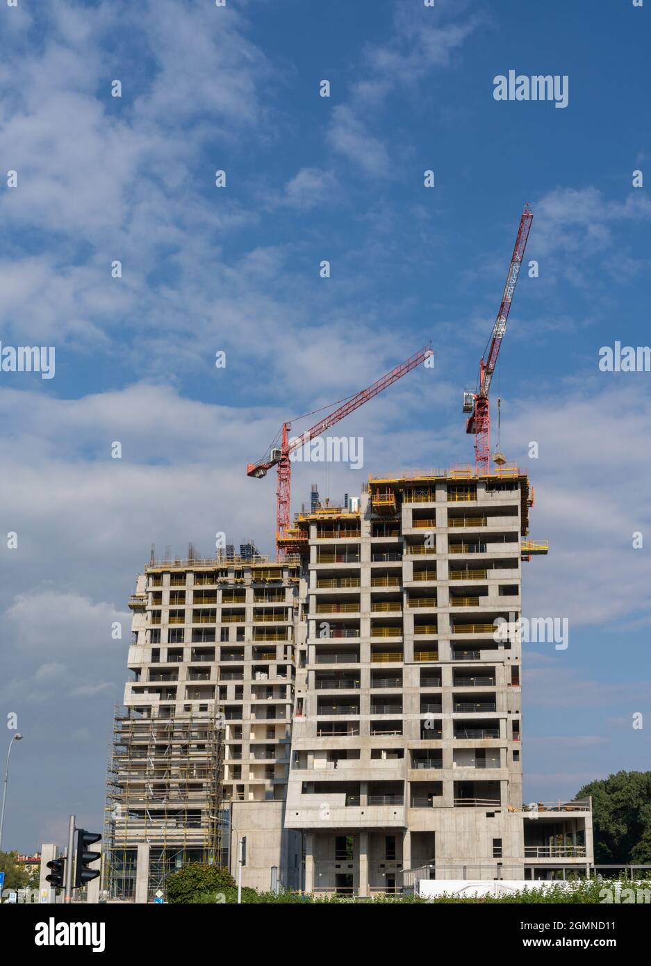 Rzeszow, Poland - 14 September, 2021: construction site with a concrete high-rise skyscraper building and scaffolding and two cranes on top Stock Photo