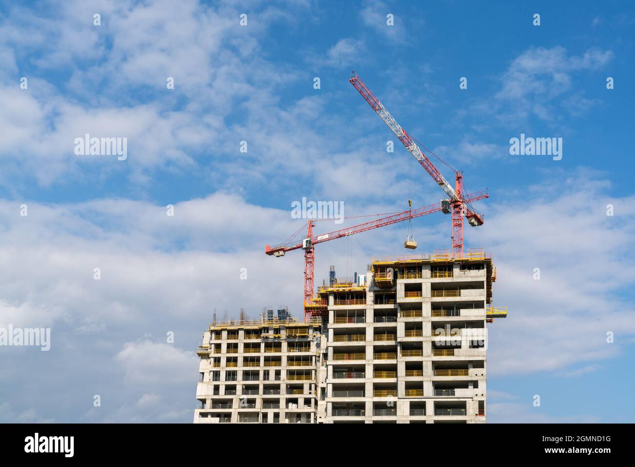 Rzeszow, Poland - 14 September, 2021: construction site with a concrete high-rise skyscraper building and scaffolding and two cranes on top Stock Photo