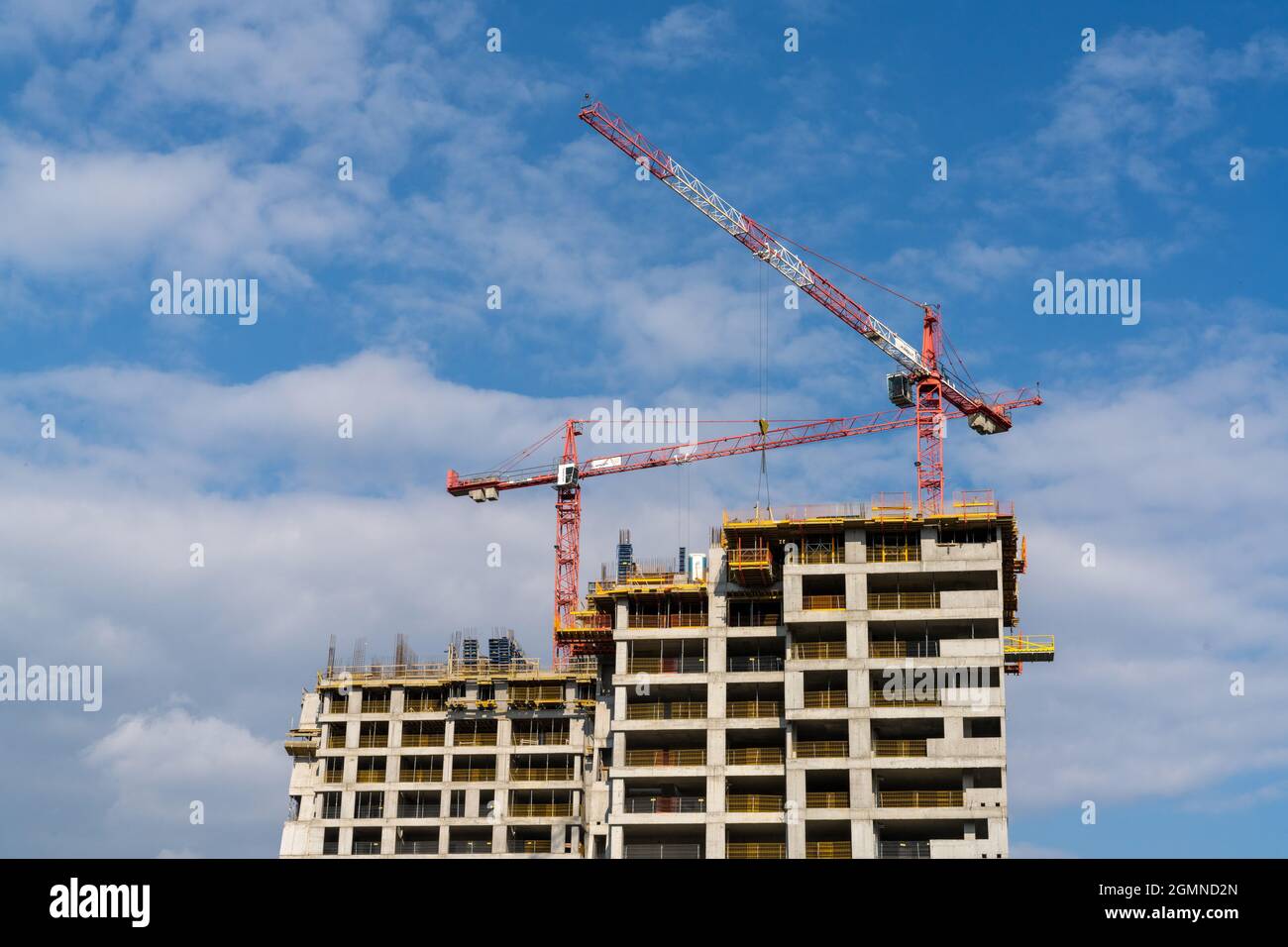 Rzeszow, Poland - 14 September, 2021: construction site with a concrete high-rise skyscraper building and scaffolding and two cranes on top Stock Photo