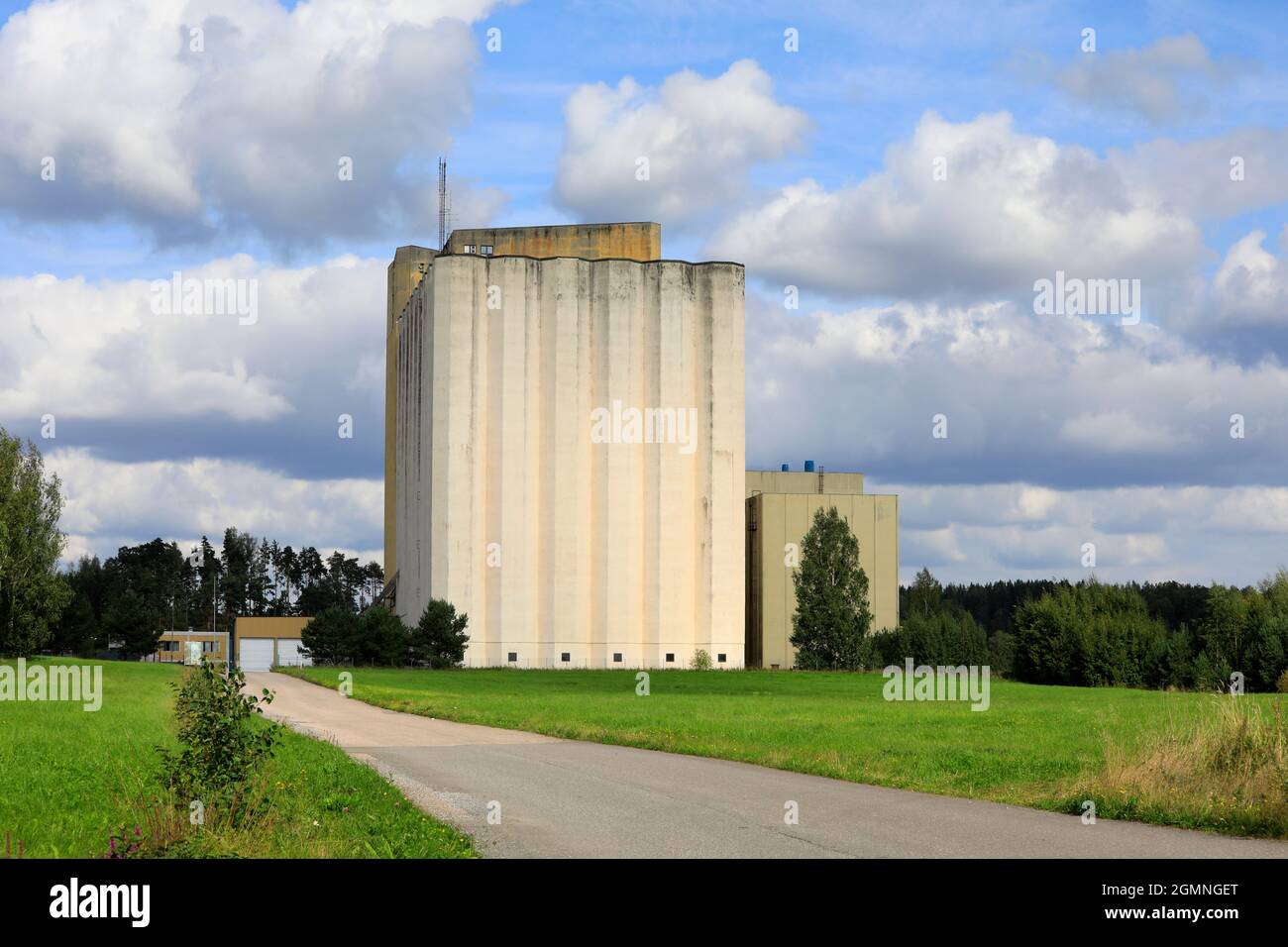 Asphalt road leads to Pernio Granary, grain elevator of Suomen Viljava Oy. This beautiful landmark in Salo is owned by State of Finland. Stock Photo