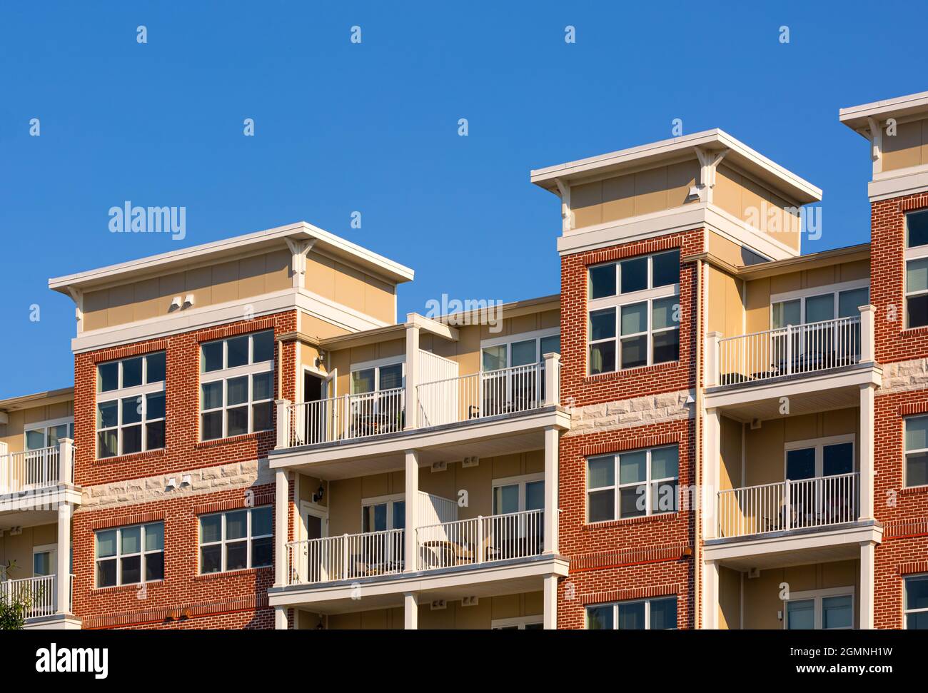Exterior of generic apartment building against a bright blue sky with ...