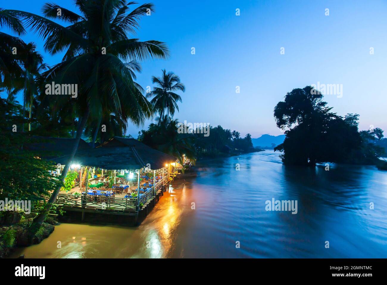 Local restaurant on the Mekong Riverside at dusk. Don Det, Don Khon Islands, tourist attractions in Laos. Selective focus. Stock Photo