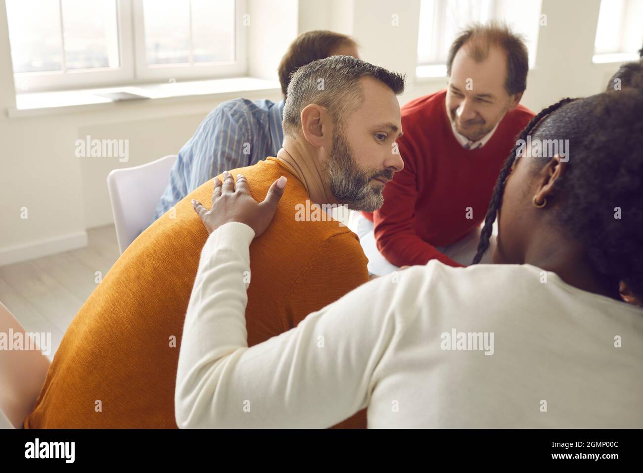 Diverse people communicating and supporting each other sitting in group therapy session Stock Photo