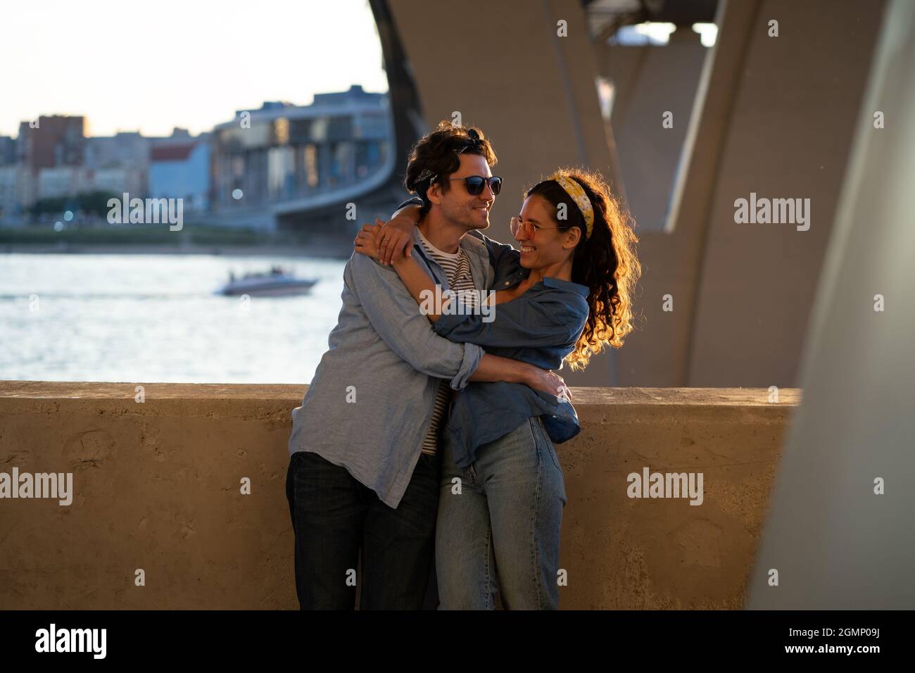 Two lovers kiss at sunset. Happy stylish couple embrace. Lovely young man and woman hug in sunlight Stock Photo