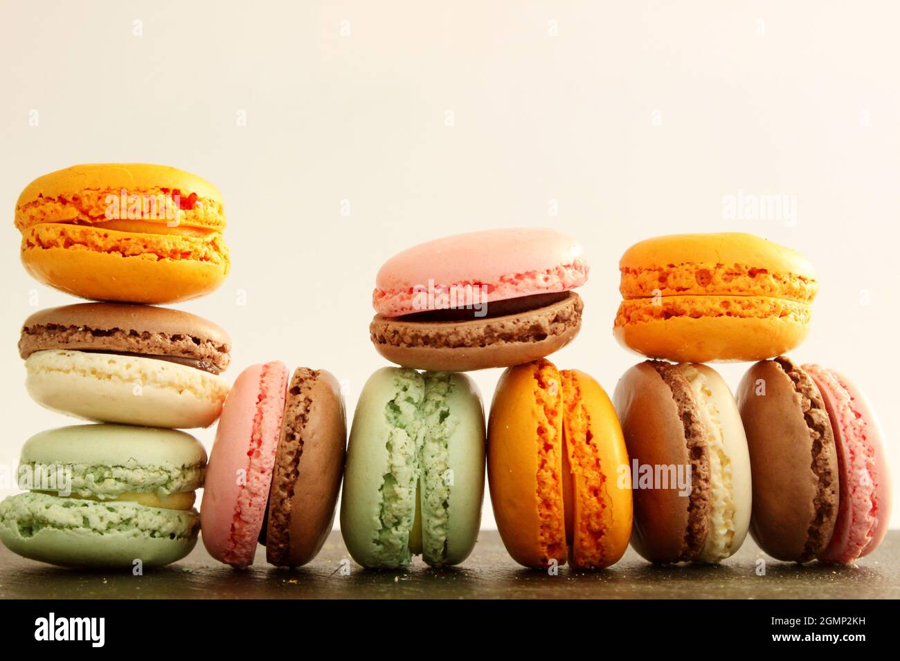 Different multicolor macarons on black stone plate Stock Photo