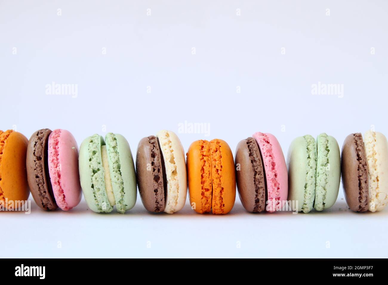 Different multicolor macarons on black stone plate Stock Photo