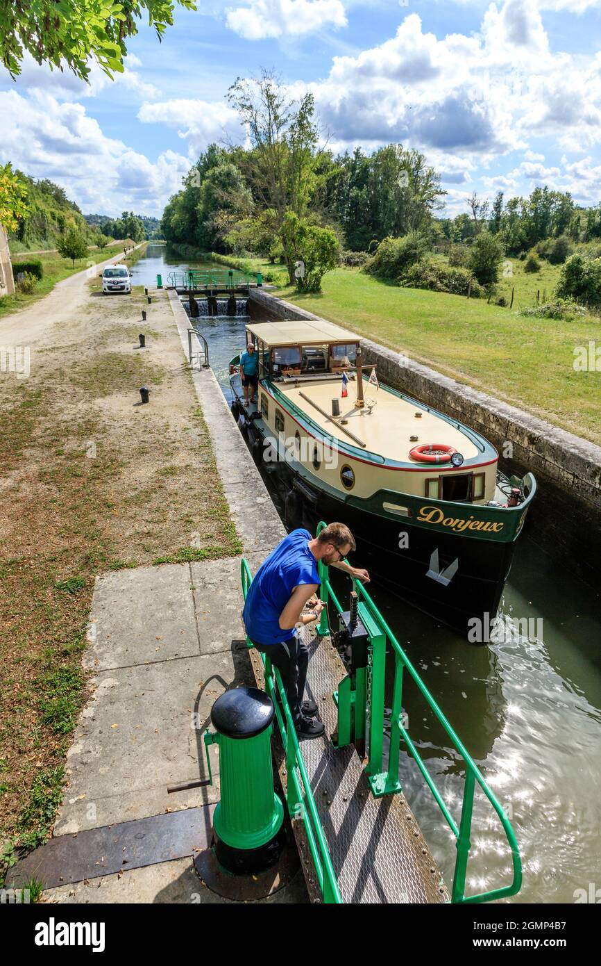 France, Yonne, Canal du Nivernais, Chatel Censoir, lock with lock keeper and houseboat, canal towpath, green road V51 Le Tour de Bourgogne by bike // Stock Photo