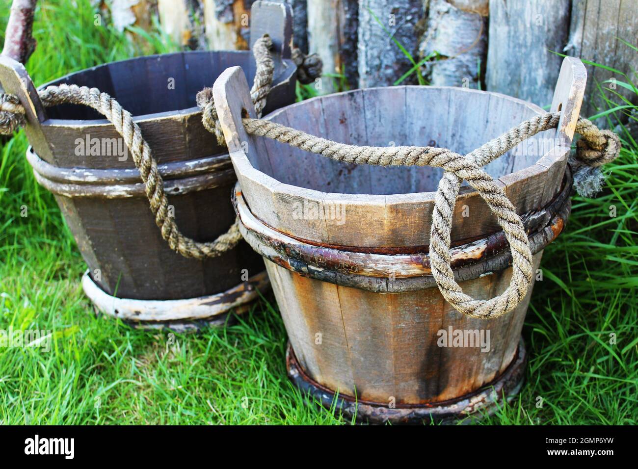 A closeup of two oldfashioned wooden water buckets, with rope handles
