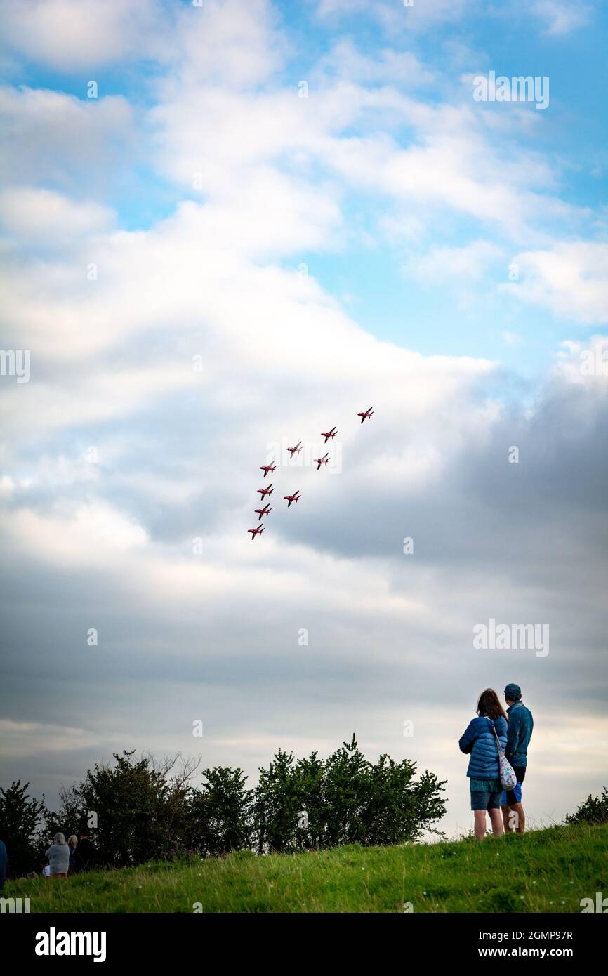 Sidmouth, September 2021: A young caucasian couple watching the (RAF) Red Arrows perform with their BAE Hawk jet aircrafts at Sidmouth Air Show Stock Photo