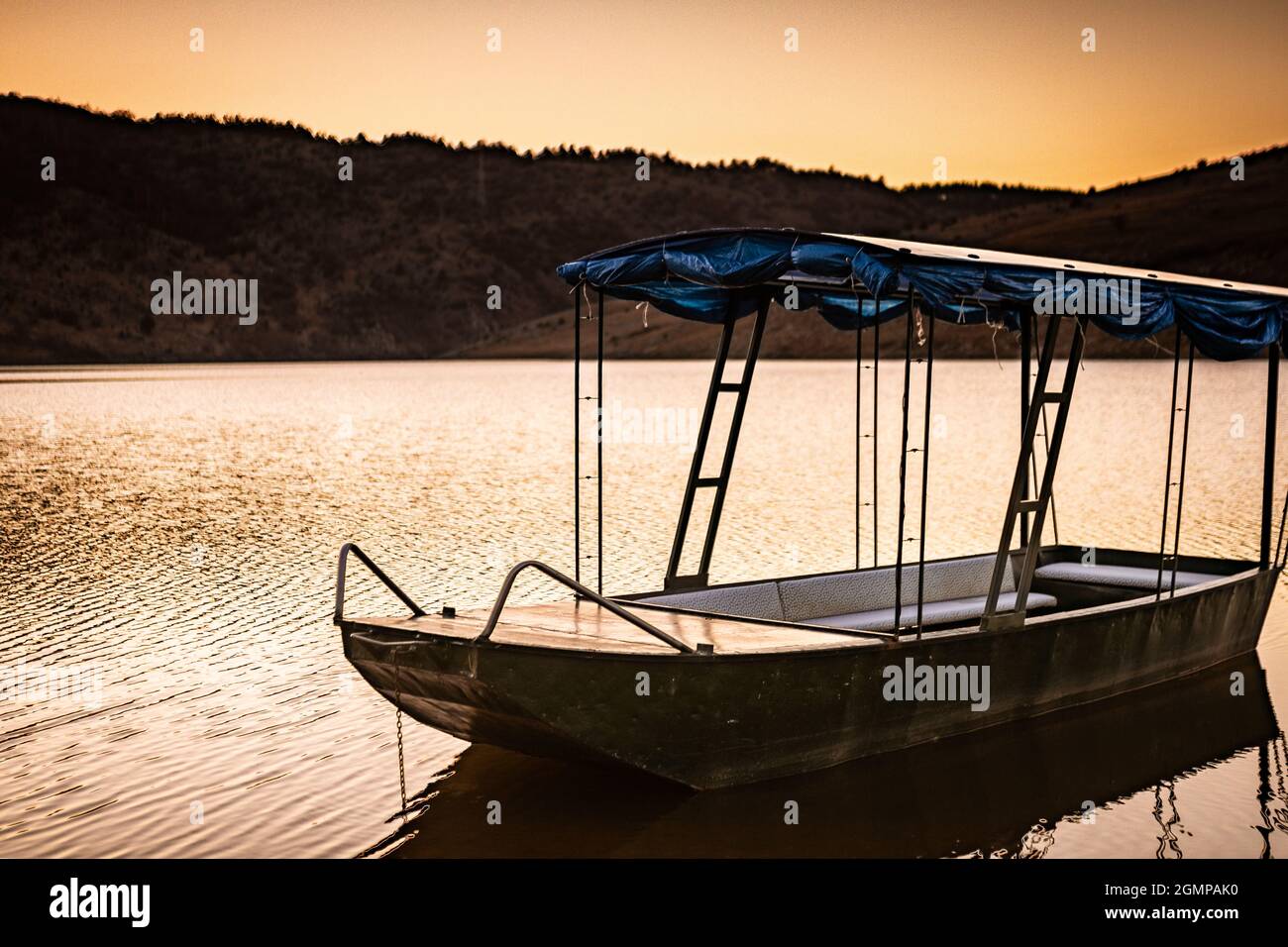 Boat on the calm lake during sunset Stock Photo - Alamy