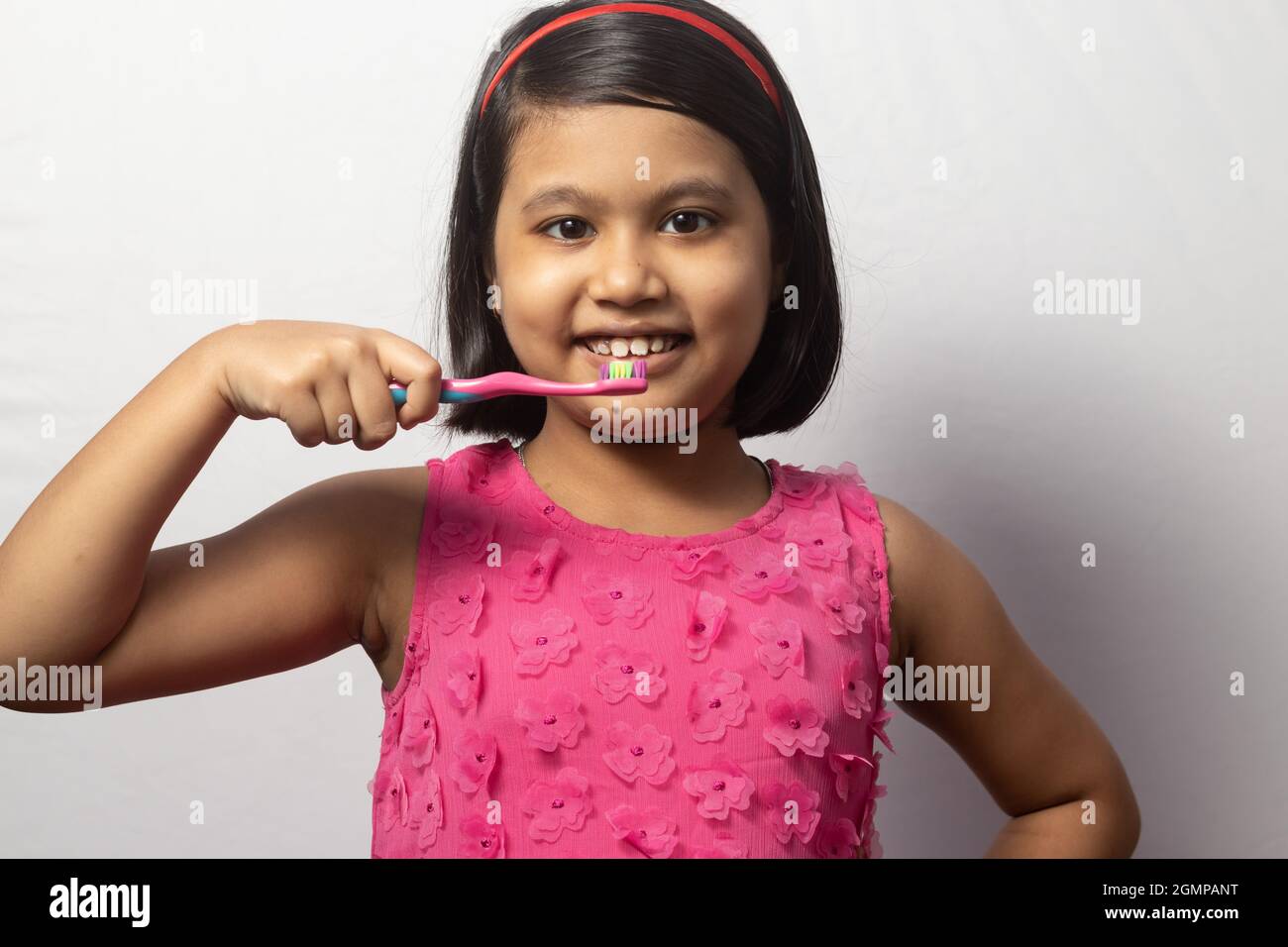 Portrait of an Indian girl child brushing teeth with toothbrush on ...