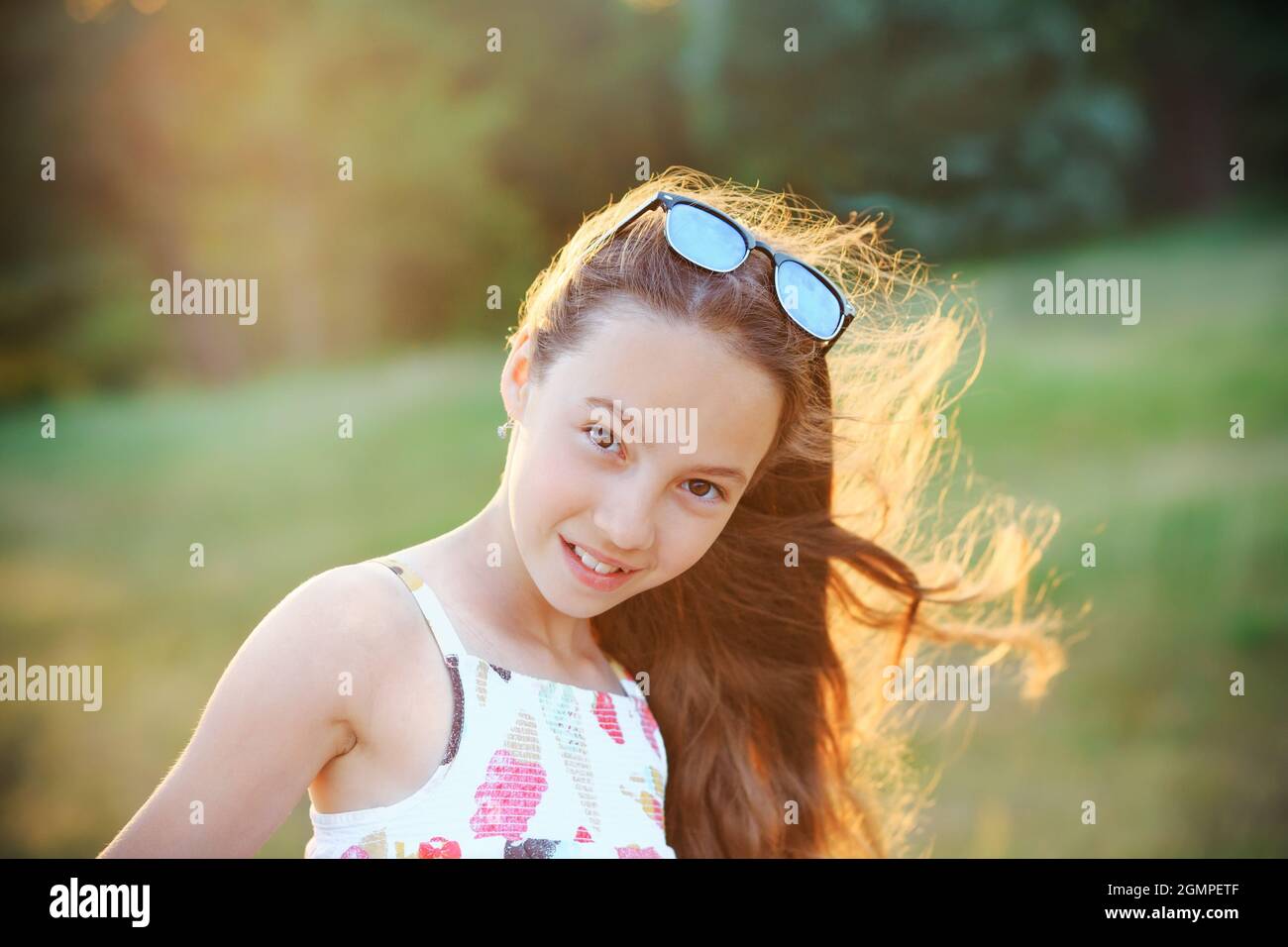 Beautiful teenager girl  with happy facial expression looking at camera with joy. Close up. Front view. Happy child outdoors Stock Photo