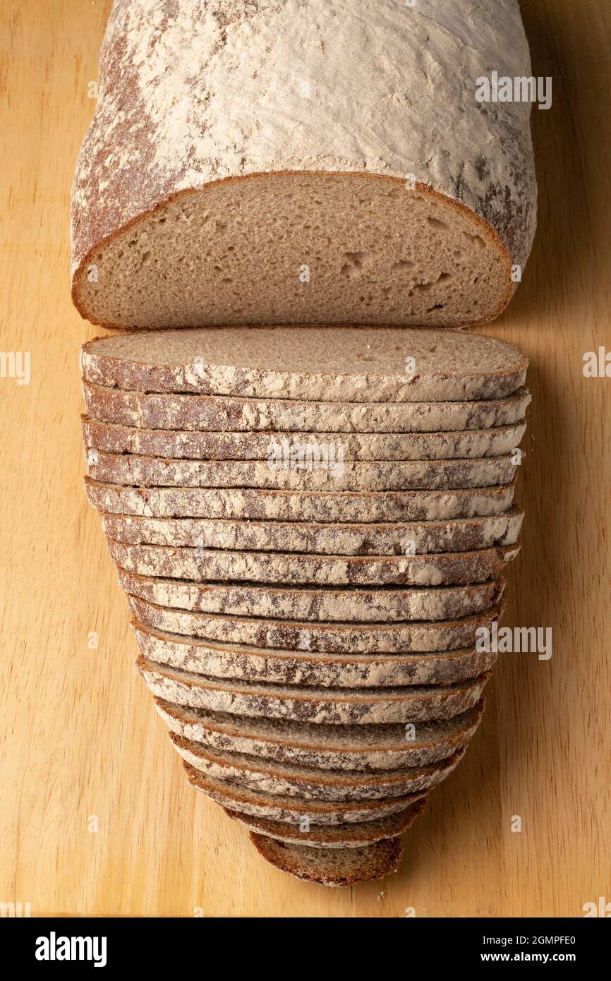 Sliced traditional German sourdough loaf of bread on a cutting board seen from above Stock Photo