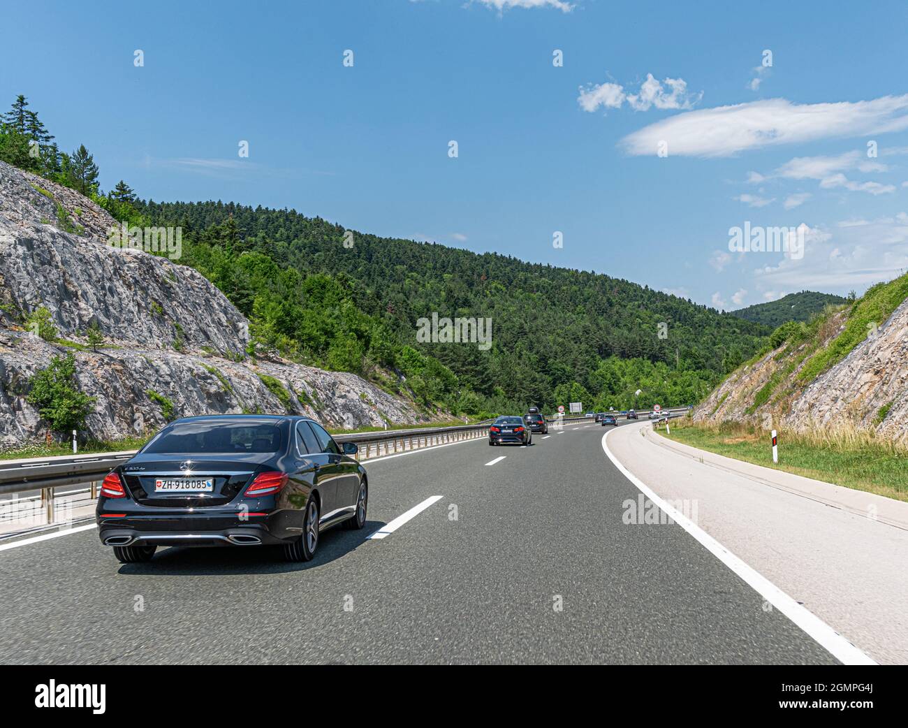Mercedes-Benz E 300 and other cars drive along the highway Stock Photo