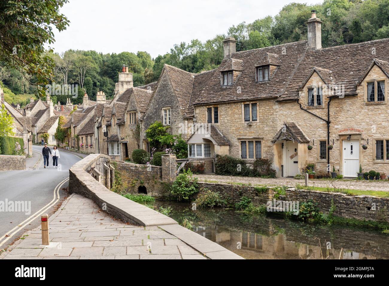 The picturesque traditional stone cottages alongside By Brook river bridge in the unspoilt Cotswold village of Castle Combe, Wiltshire, England, UK Stock Photo