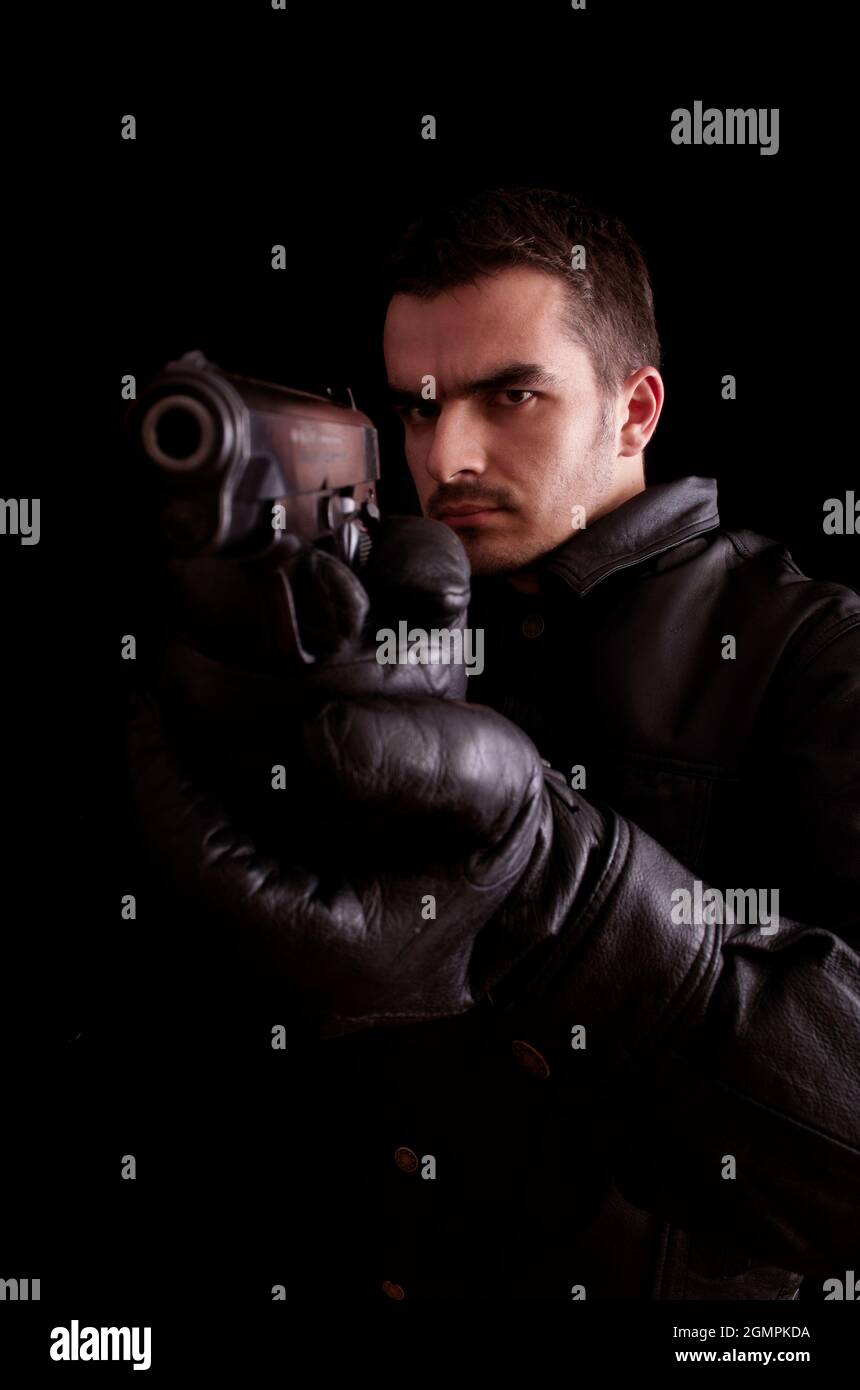 Young man holding a gun Stock Photo - Alamy