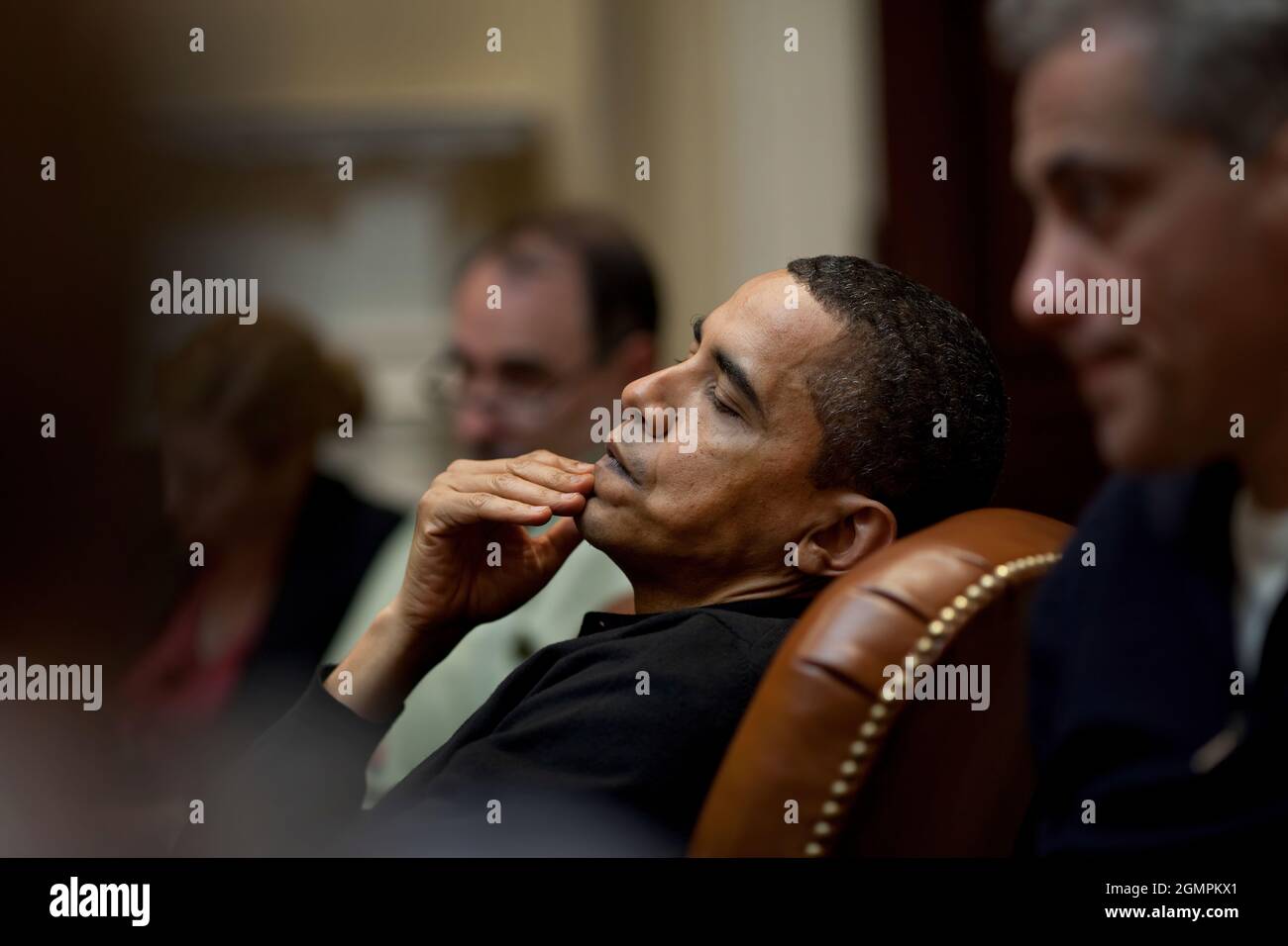 President Obama reflects during an economic meeting with advisors in the Roosevelt Room. He is seated between Senior Advisor David Axelrod and Chief of Staff Rahm Emanuel , right. 3/15/09. Official White House Photo by Pete Souza Stock Photo