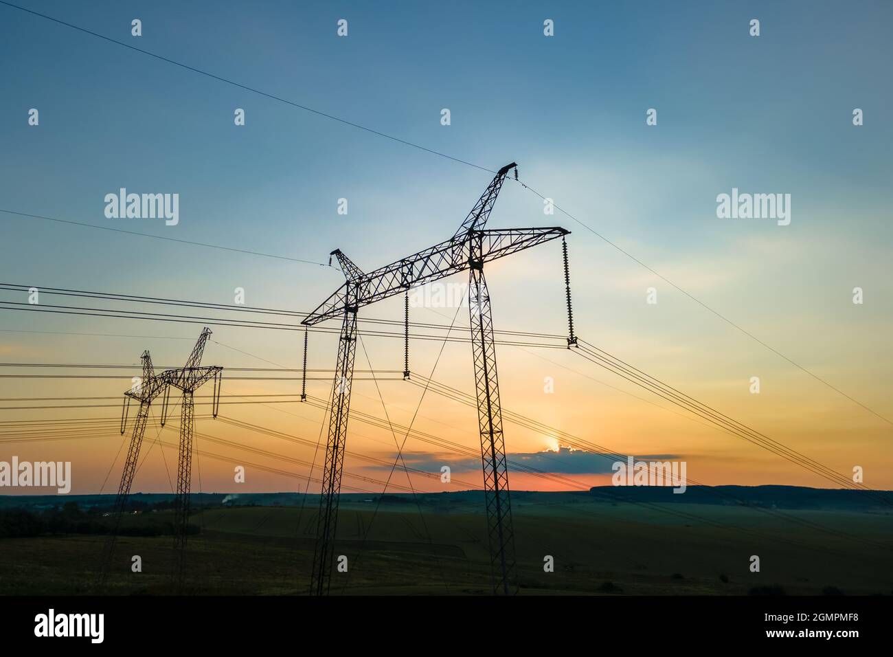 High voltage towers with electric power lines at sunset Stock Photo - Alamy