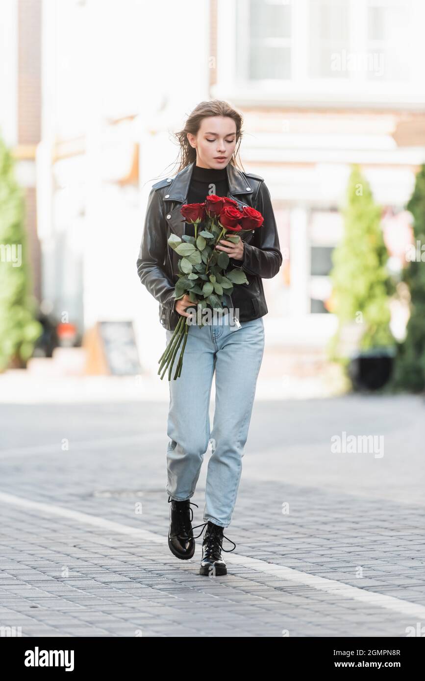leather jacket holding red roses 