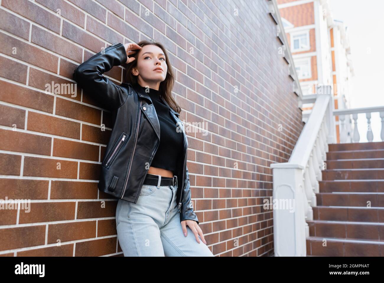 dreamy young woman in leather jacket 