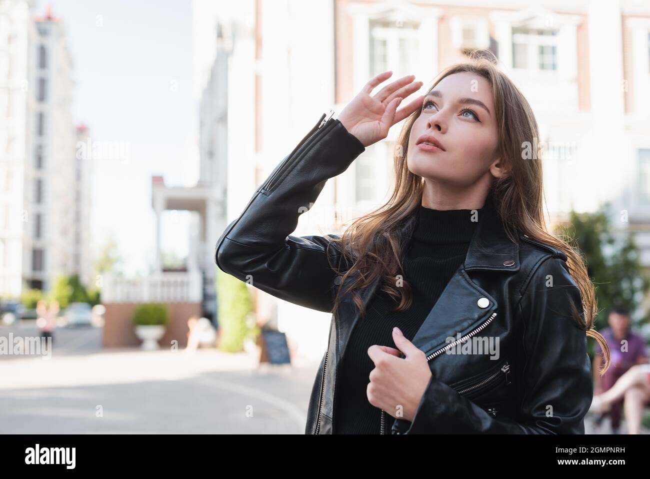 young woman in black turtleneck and leather jacket looking away on urban  street of europe Stock Photo - Alamy