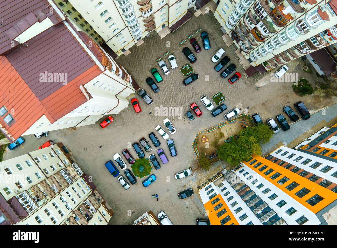 Aerial view of parked cars on parking lot between high apartment ...