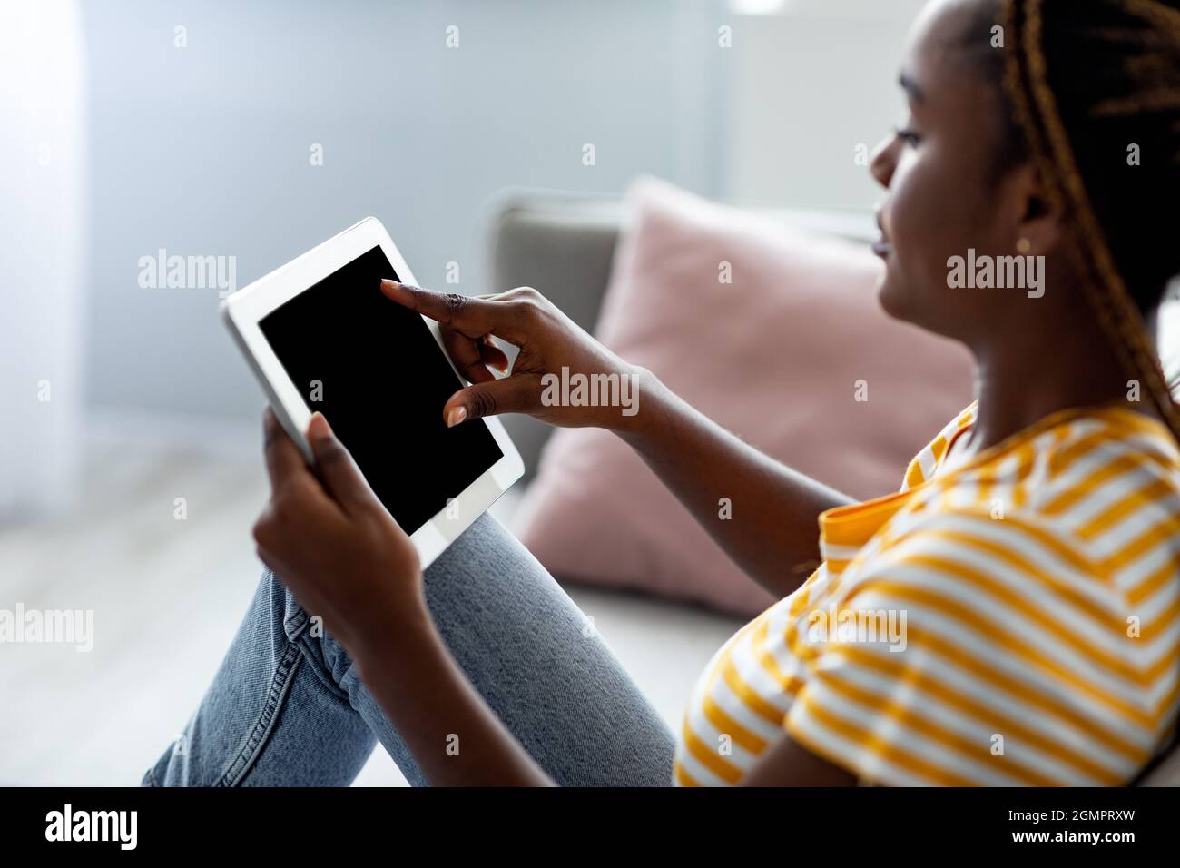 Side view of black woman using pad with empty screen Stock Photo