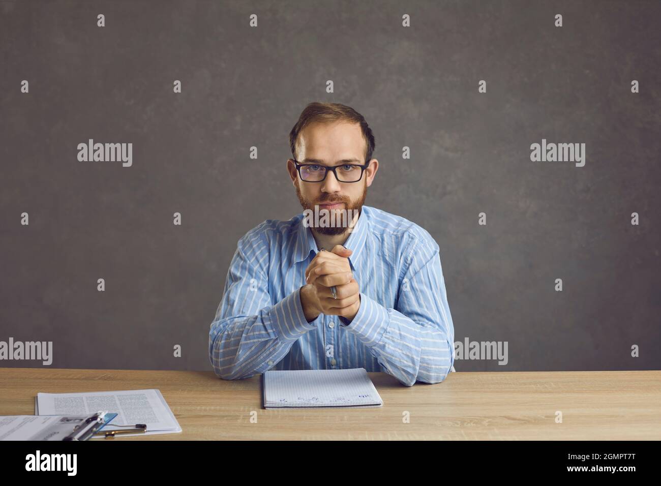 Serious confident job candidate or HR manager sitting at desk during job interview Stock Photo