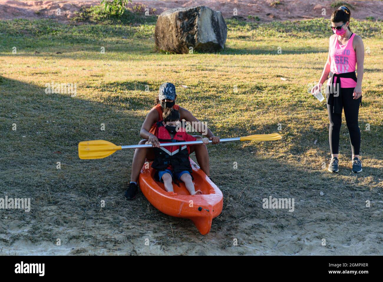 Atibaia/Sao Paulo/Brasil - on July 24 2021: 8 year old Brazilian child, being guided on how to use the paddle and kayak. Beside his mother watching. Stock Photo