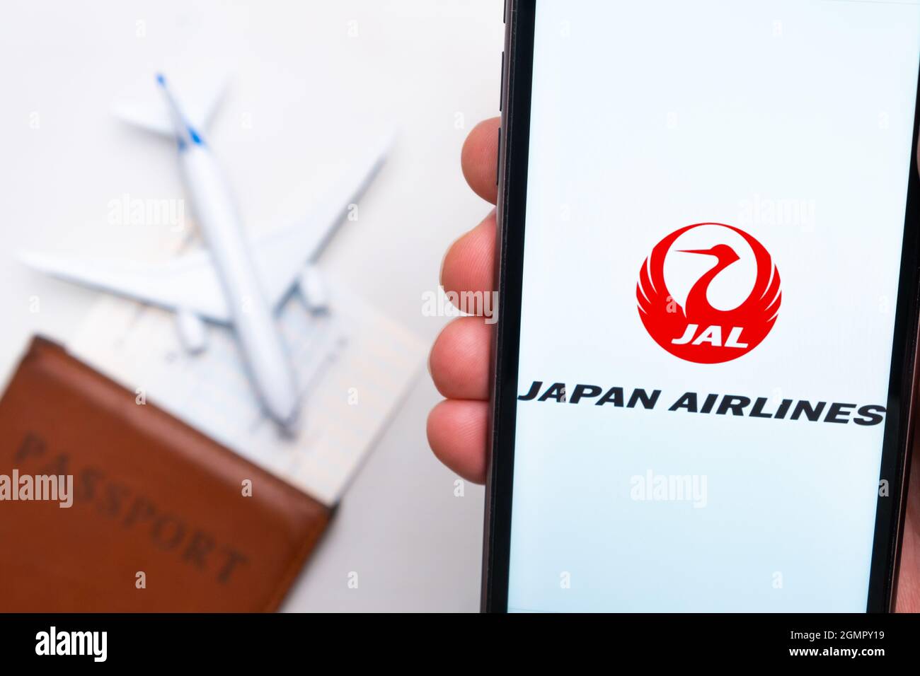 Japan airline company logo on the screen of mobile phone in man hand on