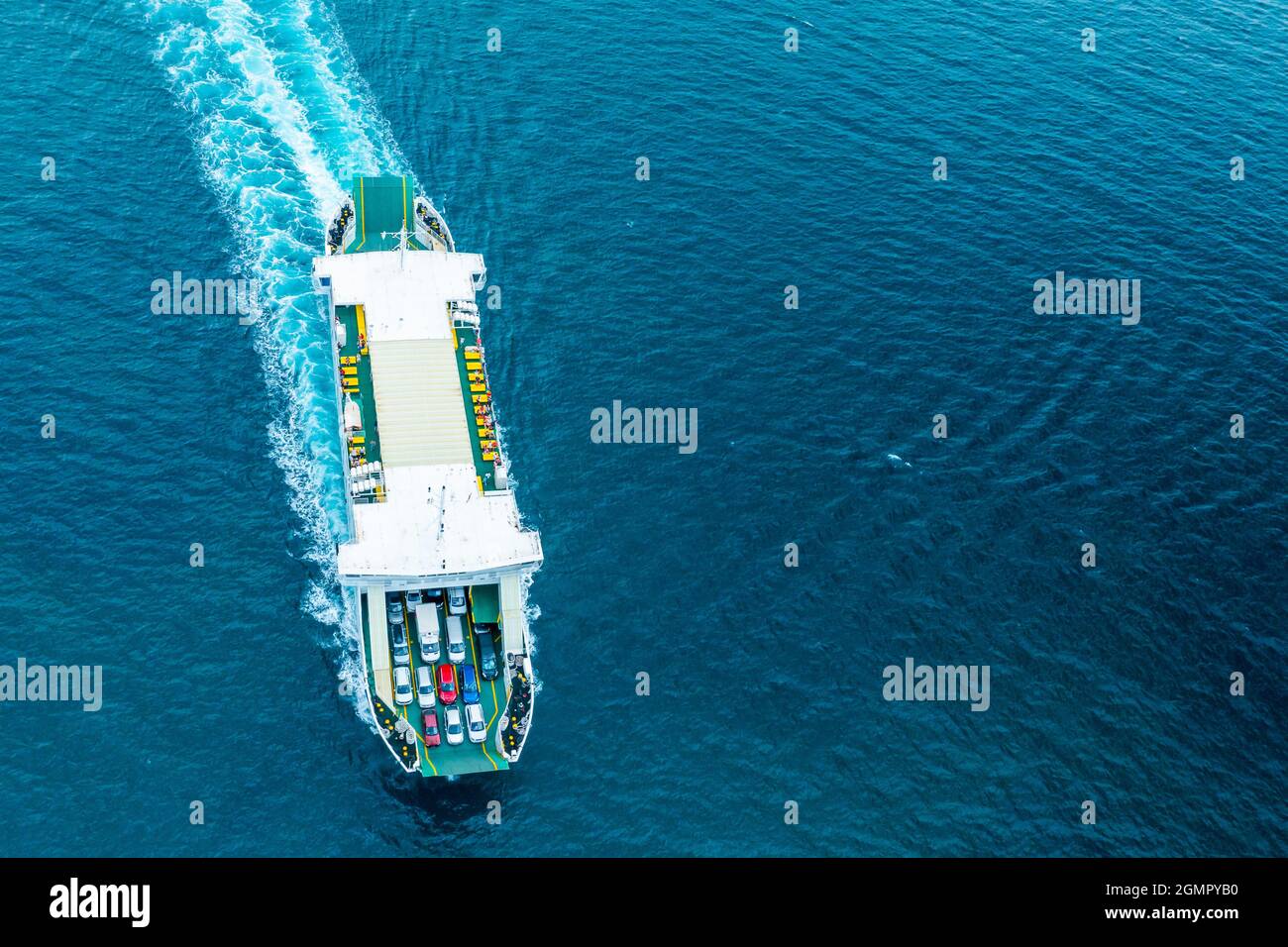 Top view on the ferry boat for car transportation on the blue water of the Adriatic sea. Automobiles on the deck.  Stock Photo