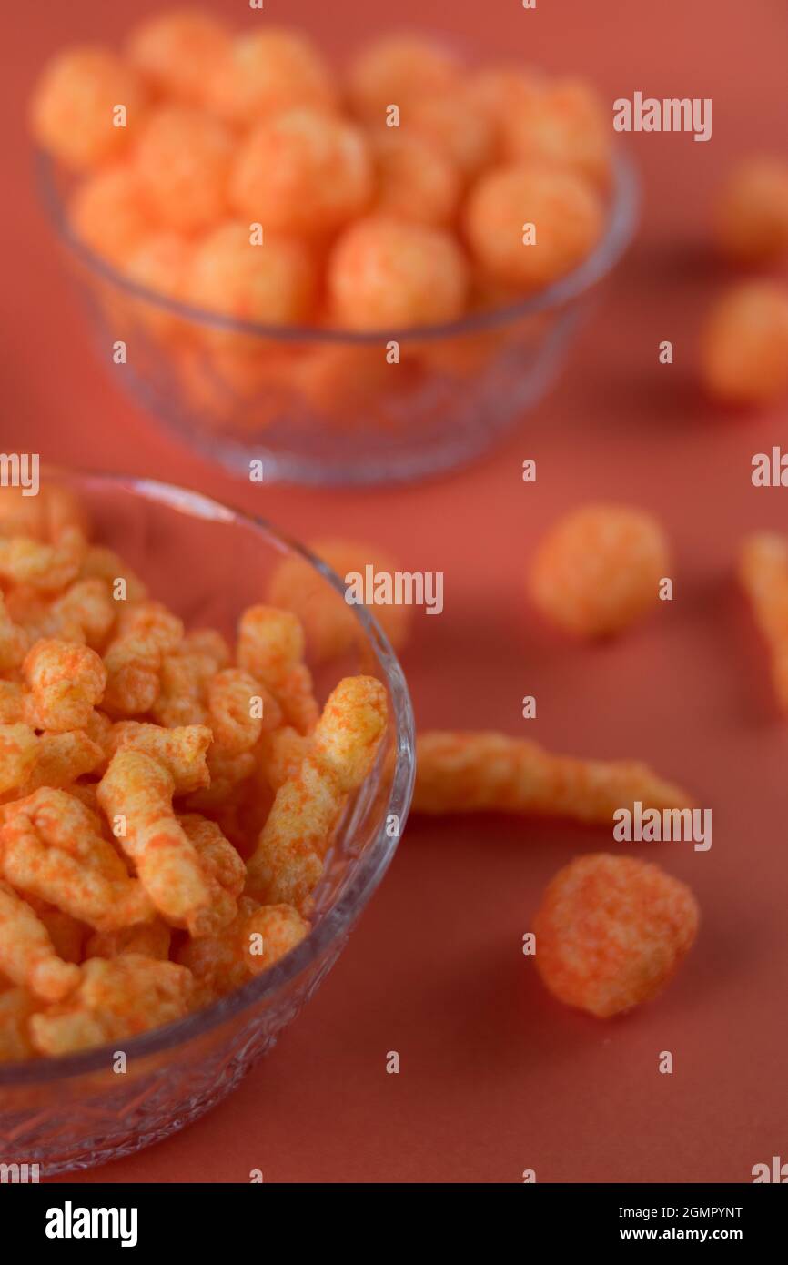 Orange cheese snacks in glass pots on an orange surface Stock Photo