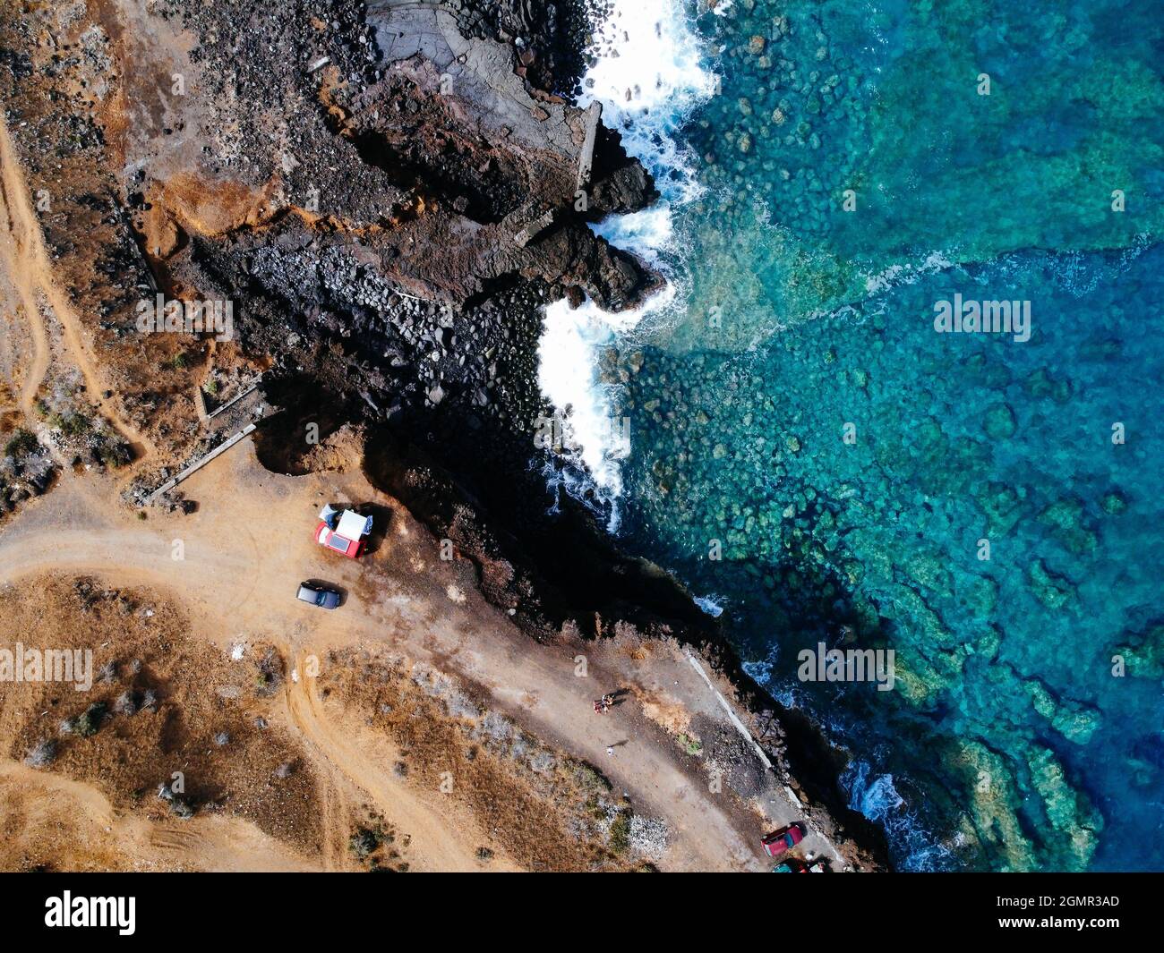 Aerial top view of rocks and sea waves in a volcanic landscape with ...