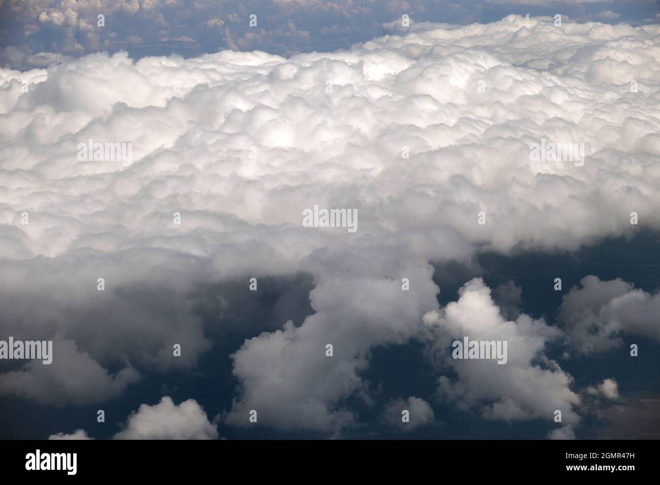 Aerial view from airplane window of white puffy clouds on bright sunny ...