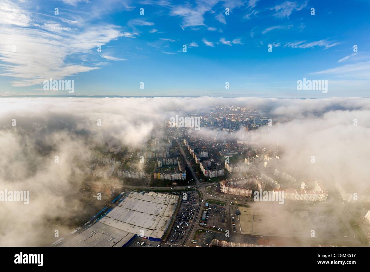 Top aerial view of fluffy white clouds over modern city with high rise ...