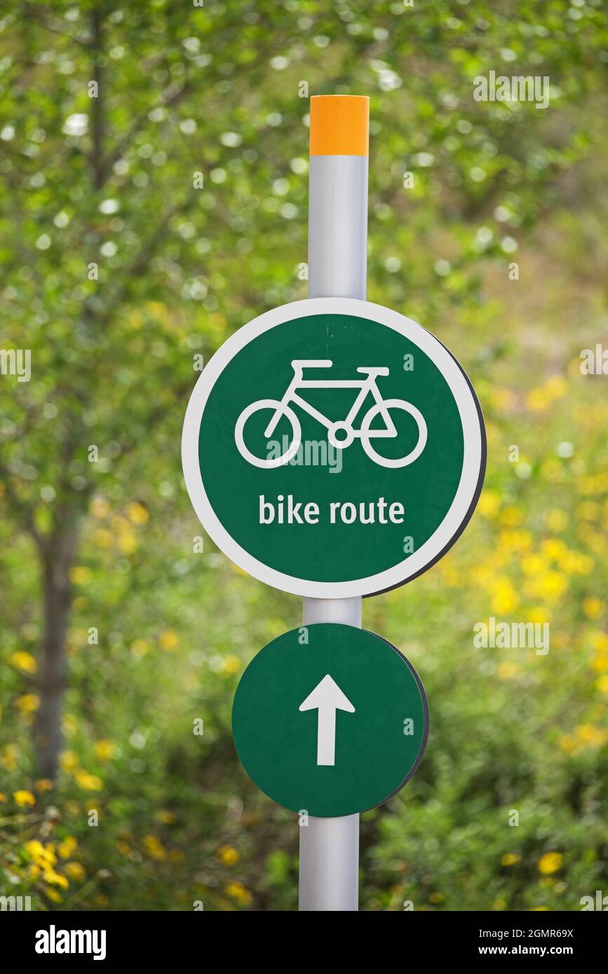green and white bike route sign on a metal pole with selective focus Stock Photo