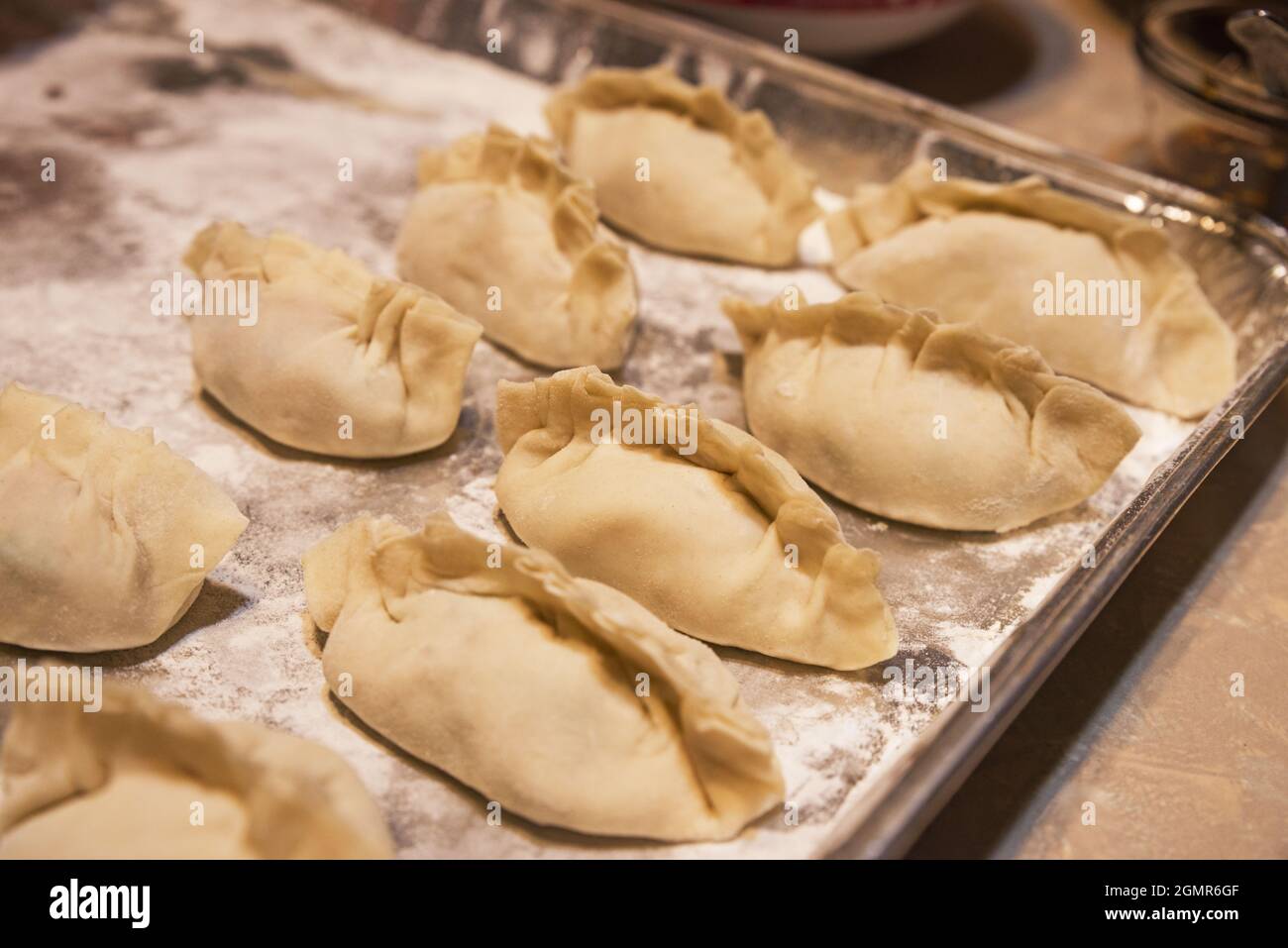 homemade Asian dumplings sitting on a tray waiting to be cooked Stock Photo