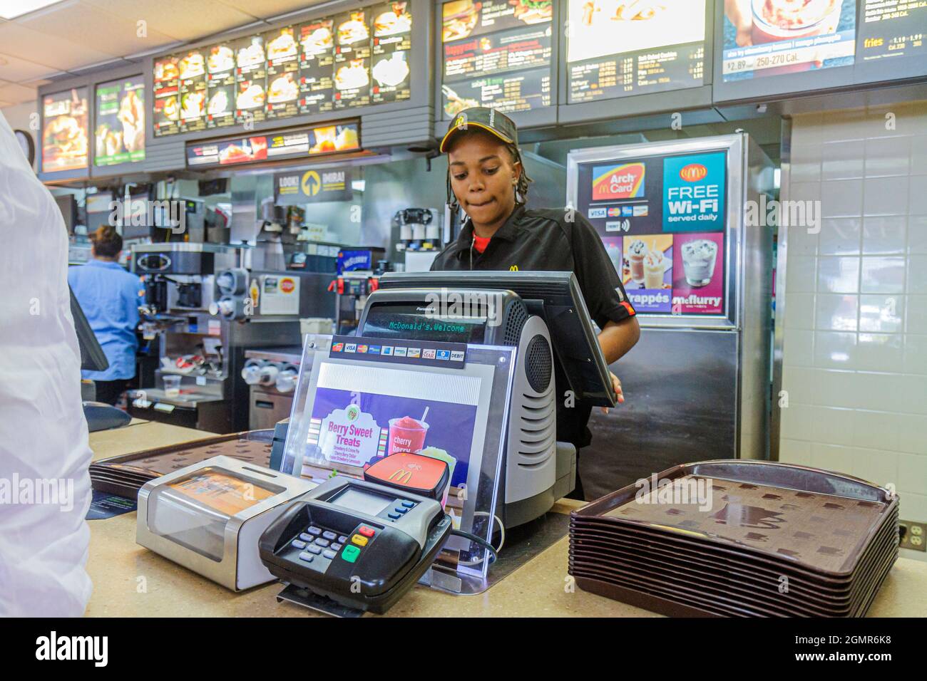 Fort Ft. Pierce Florida,McDonald's restaurant fast food counter Black girl,female teen teenager worker cashier working uniform credit card scanner Stock Photo