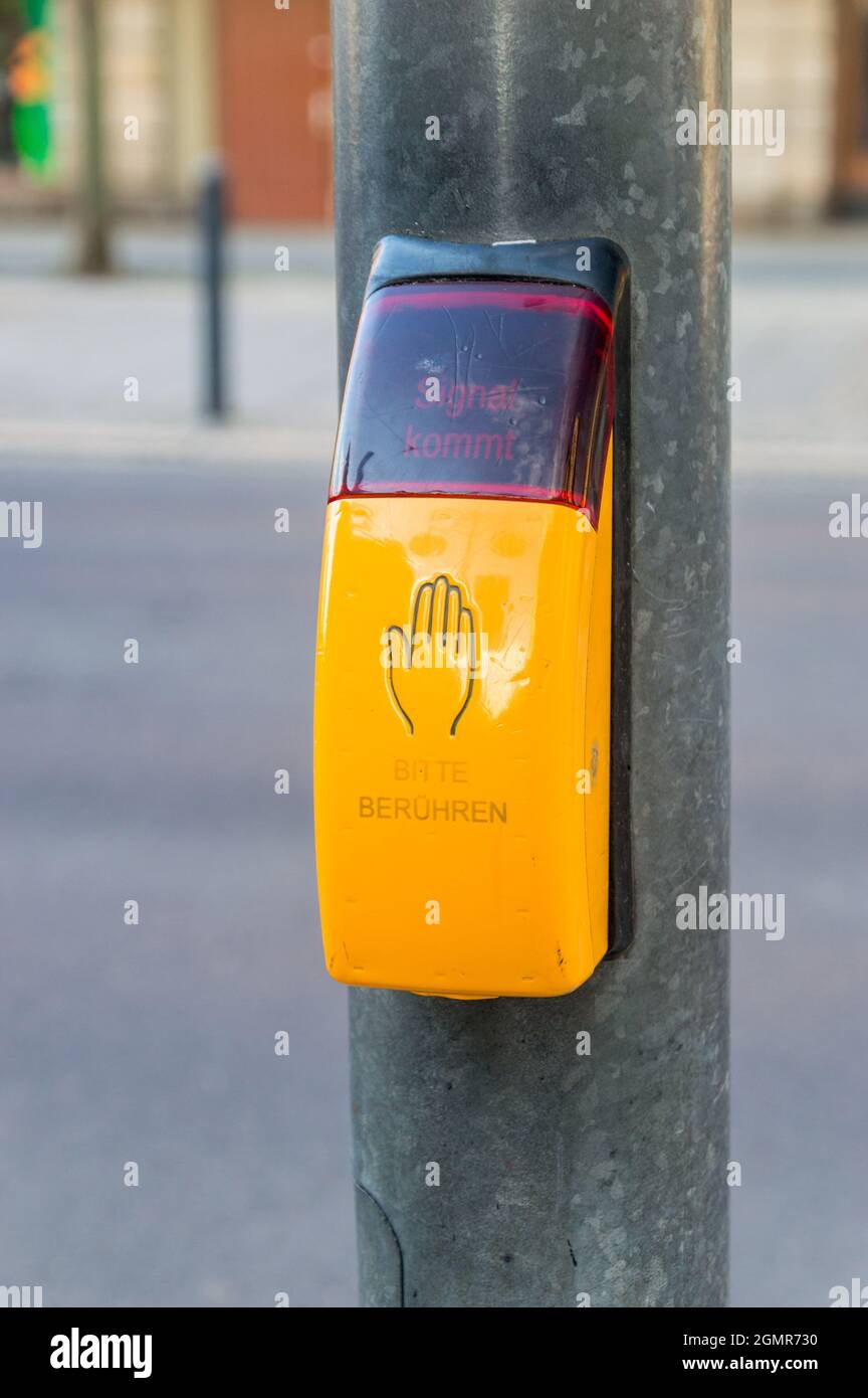Button for traffic light for pedestrians. Touch button with text please touch in german language. Stock Photo
