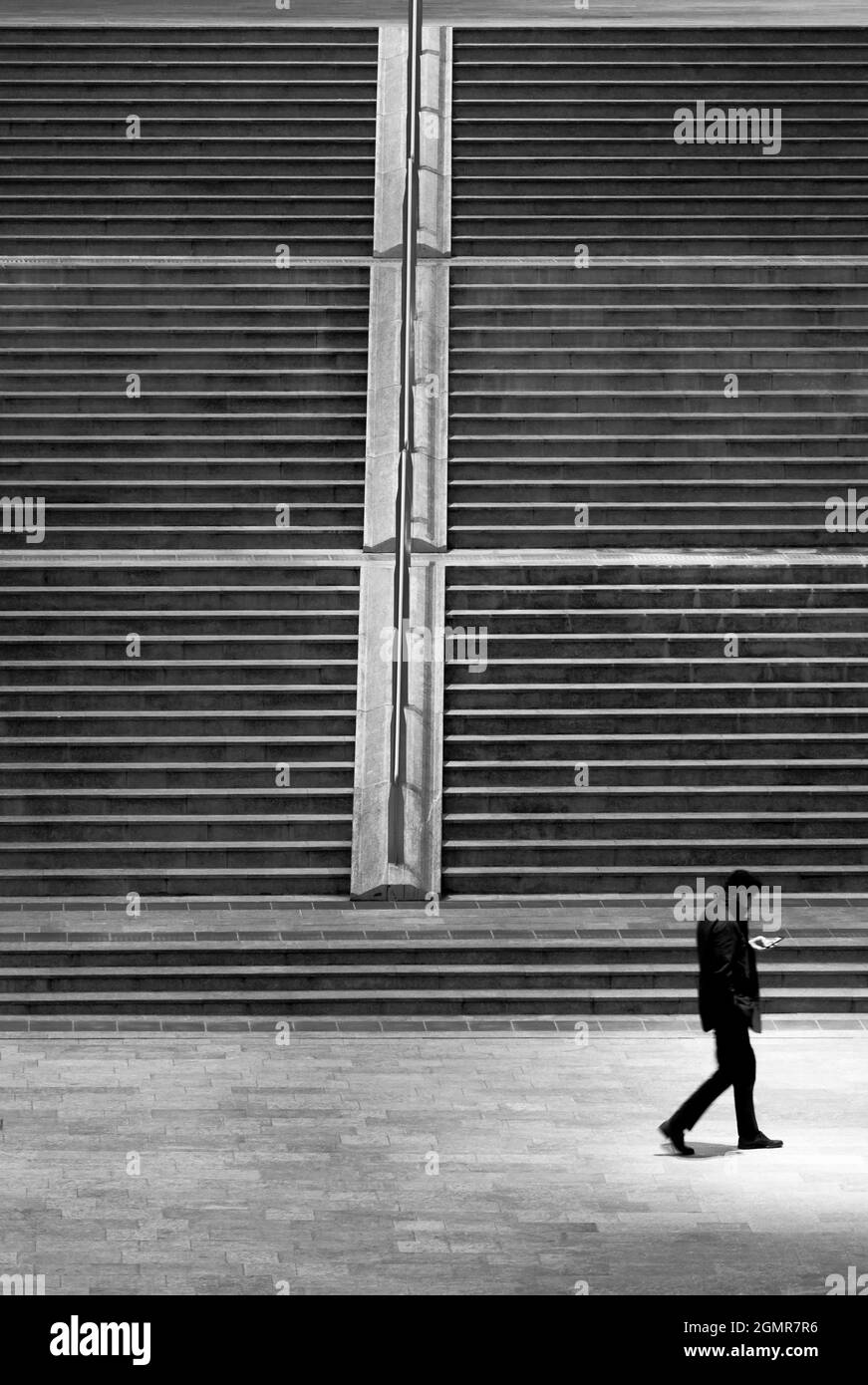 Walking man looking at smartphone Stock Photo