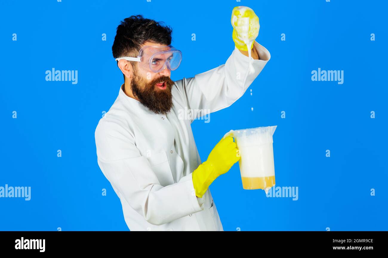 Bearded man in rubber gloves with cleaning solution or soap liquid. Disinfecting home. Domestic cleaning. Cleaning Service Worker. Stock Photo